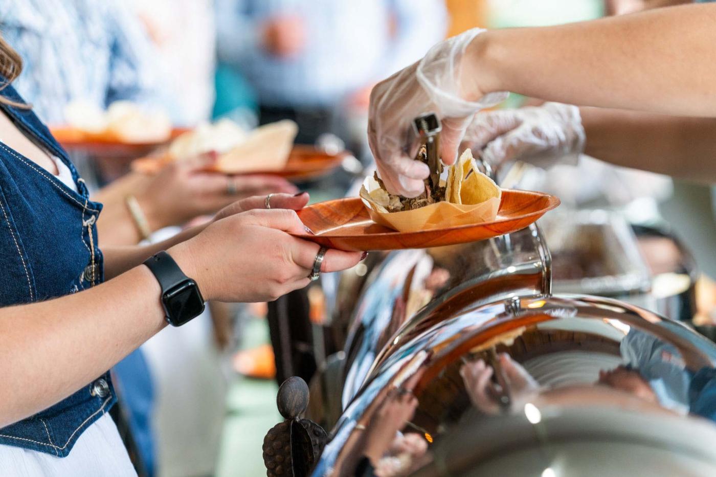 Person standing in line at a buffet line getting served