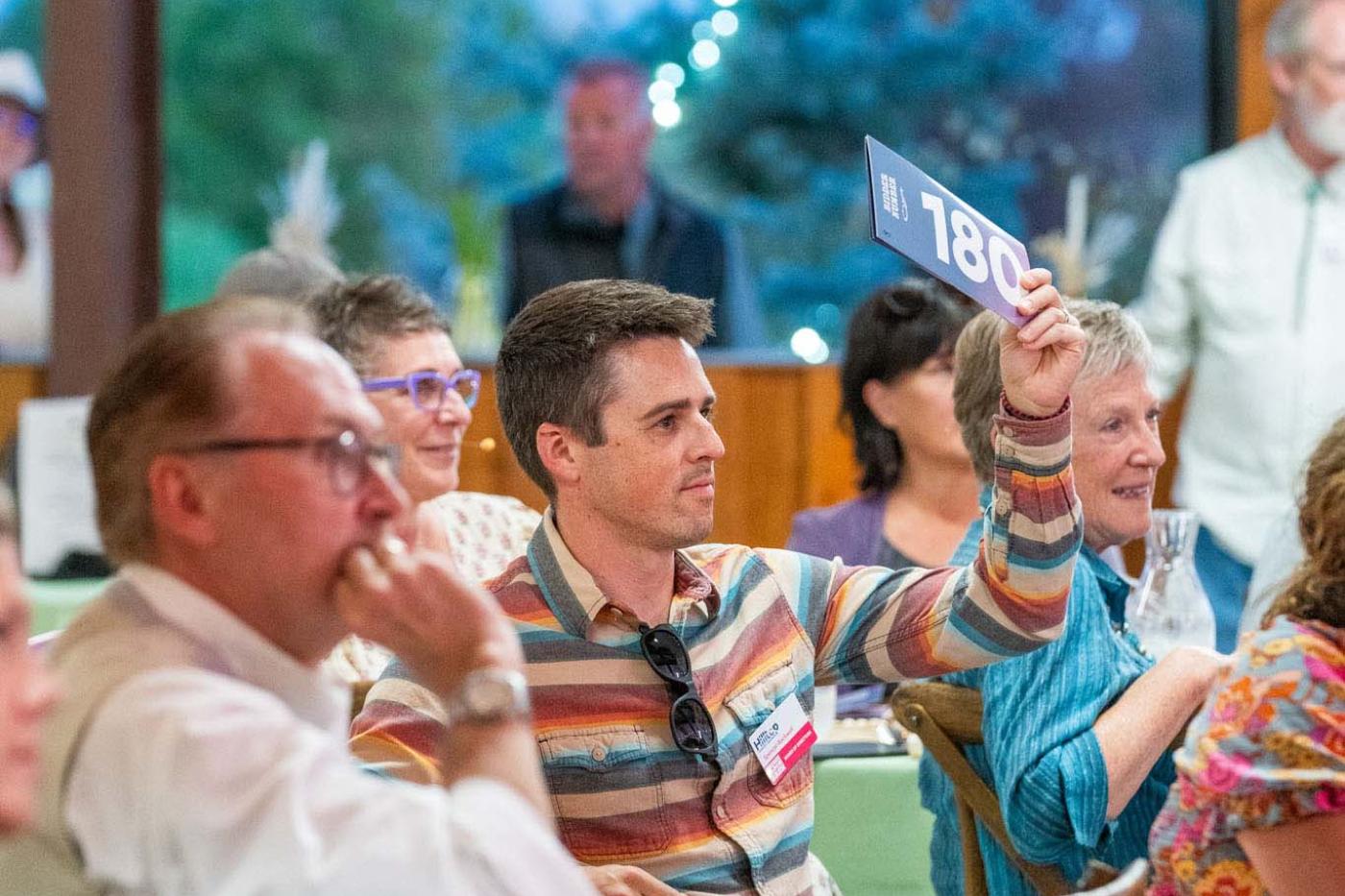 Man in audience raising bidder paddle